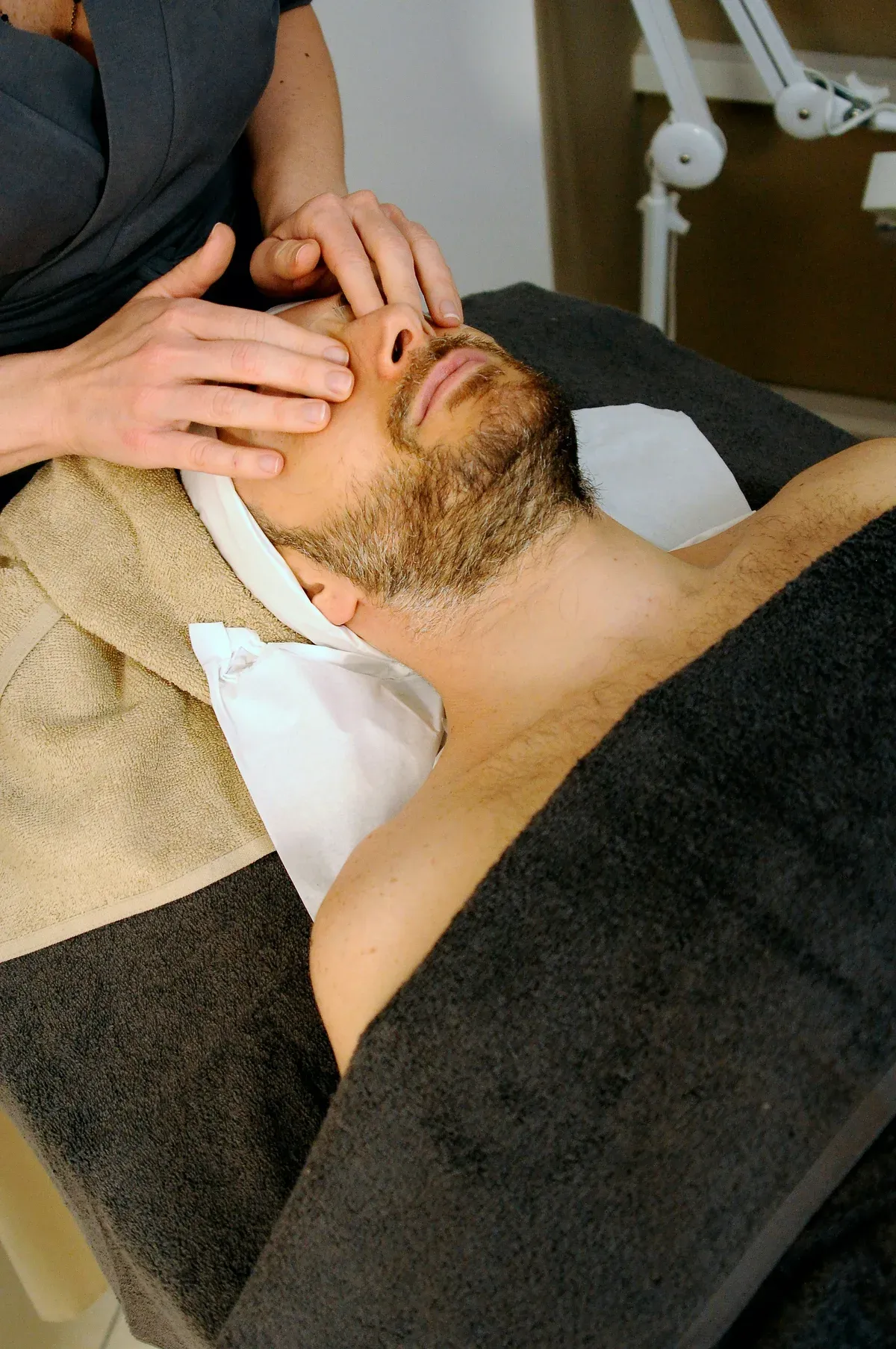 Soin et massage du cou réalisé par un professionnel sur un client masculin
