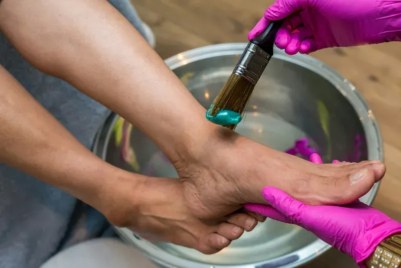 Soin des pieds et pose de vernis lors d’une pédicure à domicile