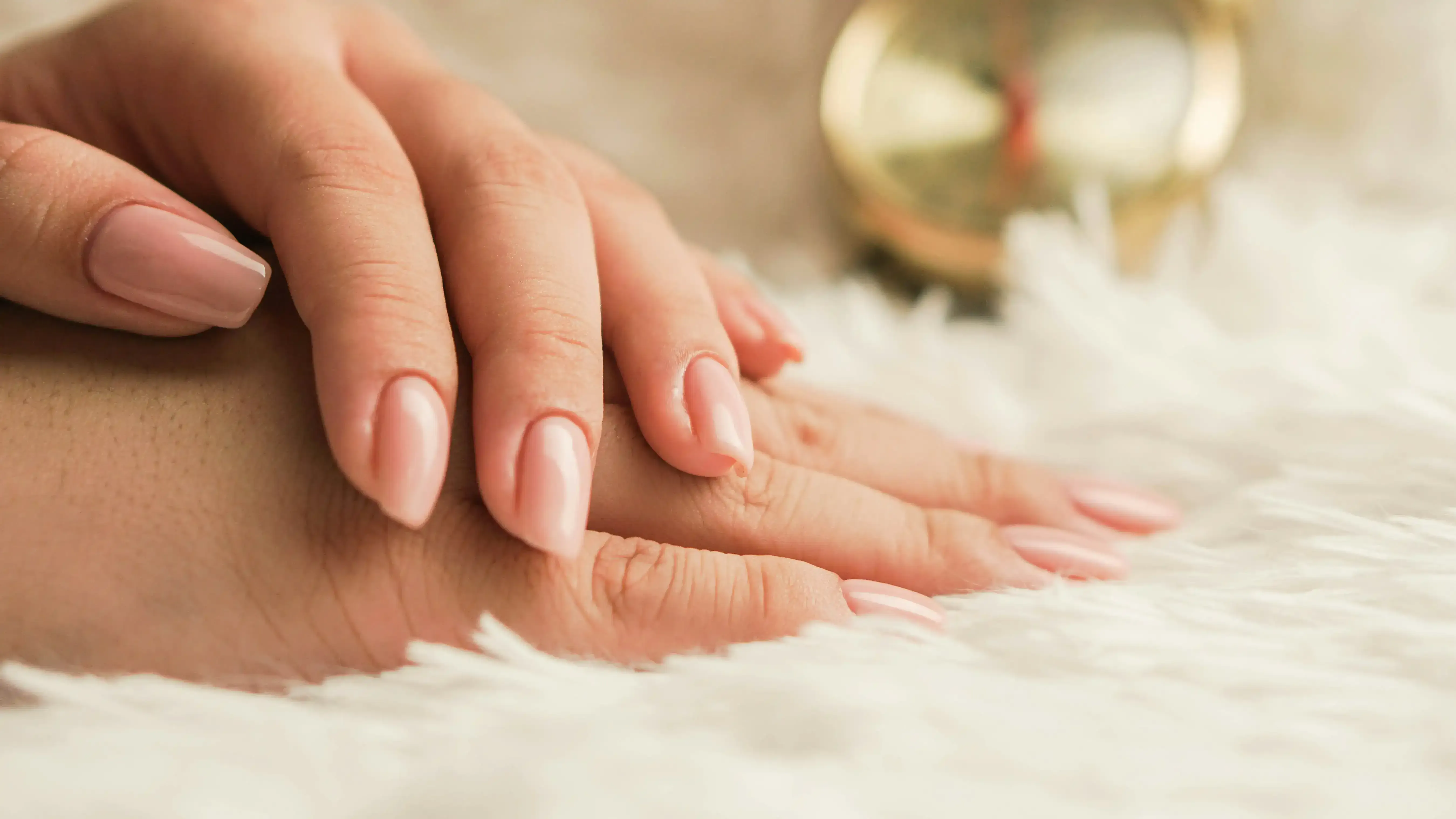 Manucure soignée — ongles en vernis nude sur fond doux